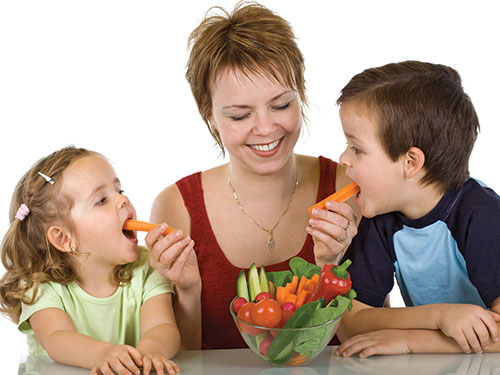 Photo: Children eating sliced carrots.