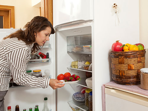 Photo: Person takes vegetables and Fruits out of the refrigerator.