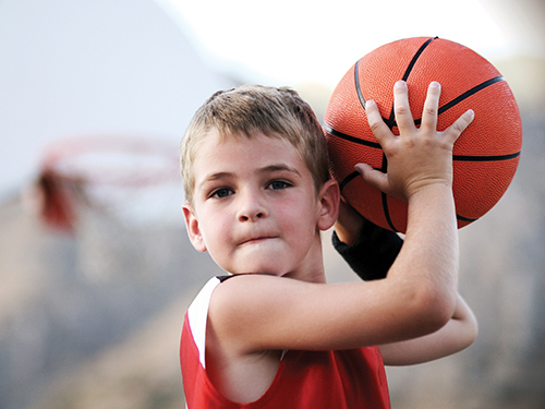 Photo: Boy playing basketball.