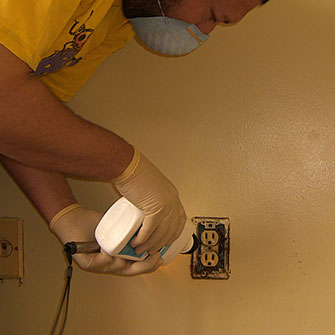 Photo of Applying insecticide dust to an outlet.