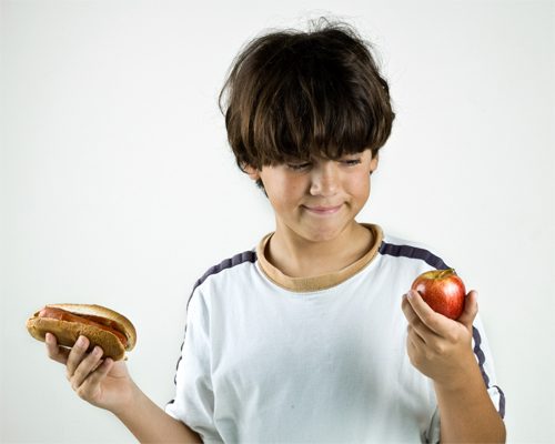 Photo: Child looking at apple in hand.
