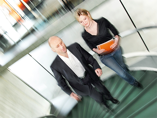 Photo: Two people walking up a stair.