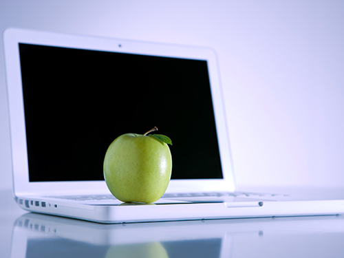Photo: One apple a day, an apple on a laptop.