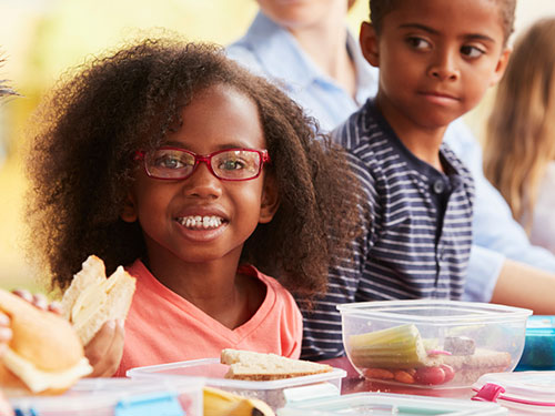 Photo: Teens in kitchen making school lunches.