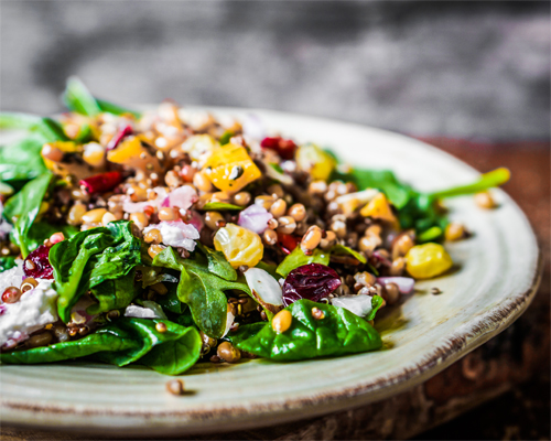 Photo: Healthy salad with spinach quinoa and roasted vegetables.