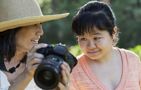 Woman shoing another woman pictures in a digital camera.
