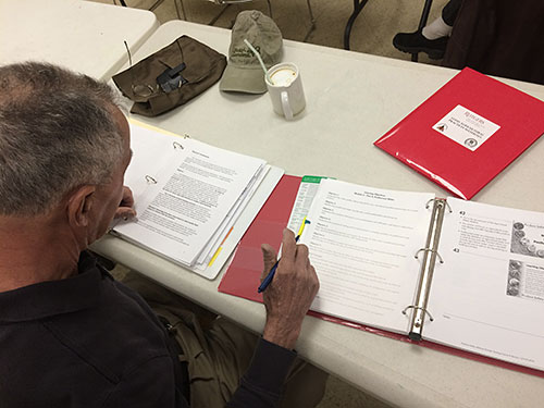 Man at desk writing in a binder.