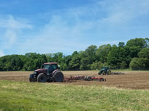 A tractor preparing a field for planting.
