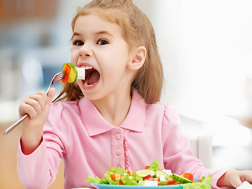 Photo: girl eating vegetables.