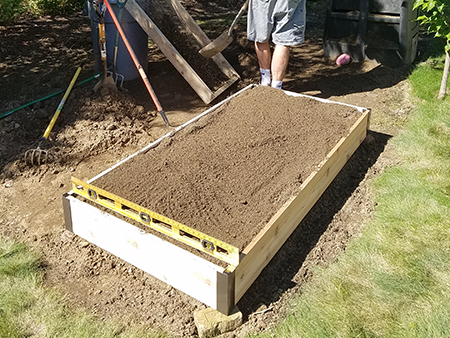Filling a raised bed with soil.