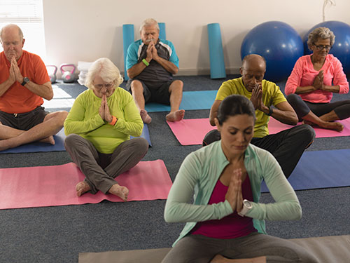 Older adults on work out bikes waving their hands.