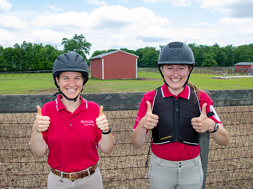 Photo: Two women show off some of the safety equipment that should be worn when riding horses. The helmet and vest are two of the most important pieces of equipment that a rider can wear.