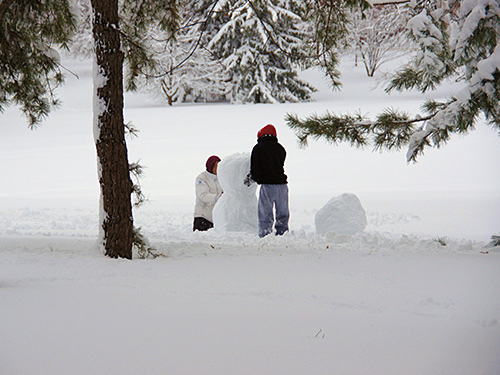 Photo: kids making a snowman.